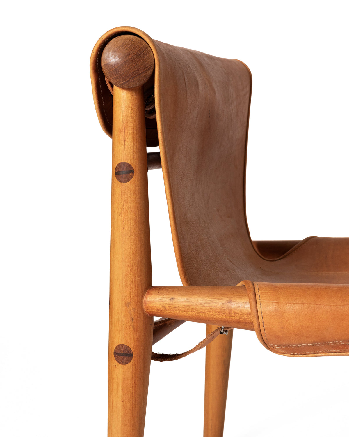 wooden chair with a curved tan leather seat and backrest, showing the wood grain and leather texture against a white background.