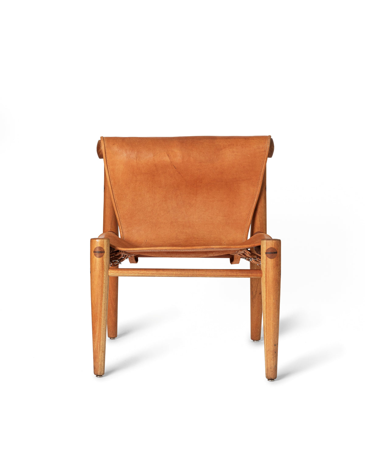 A mid-century modern wooden armchair with a warm tan leather sling seat and backrest, shown from the front on a clean white background.