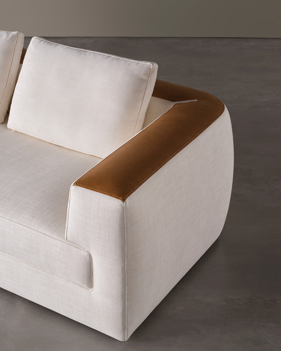 Modern sofa with white cushions and brown armrests 
