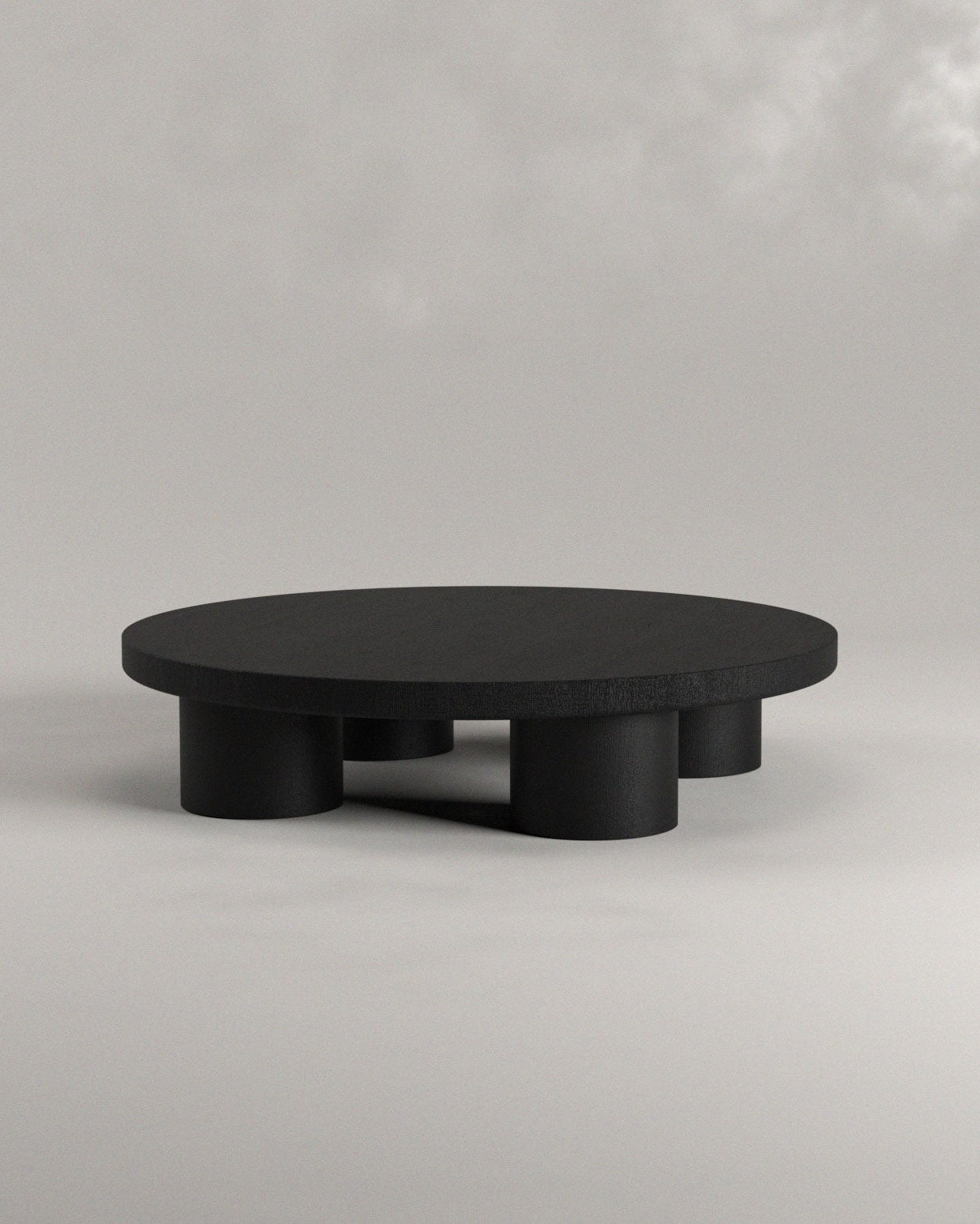 Black round coffee table on a light gray background